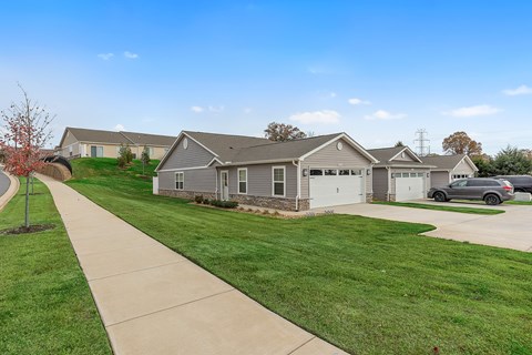 A house with a grey roof and a white garage door.