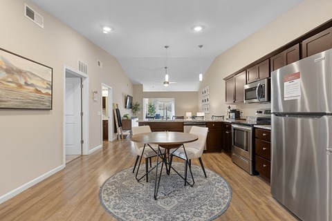 A kitchen with a table and chairs in the middle of the room.