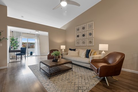 A living room with a brown leather chair and a white couch.