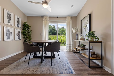 A dining room with a table and chairs.