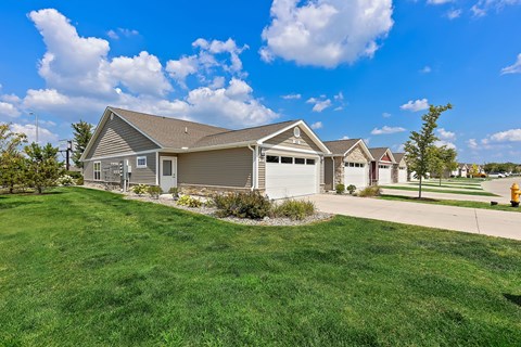 A house with a garage and a driveway in front of it.