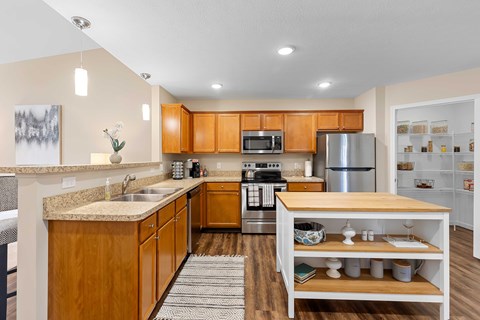 A kitchen with wooden cabinets and a stainless steel refrigerator.