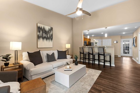A living room with a white couch, a coffee table, and a painting on the wall.