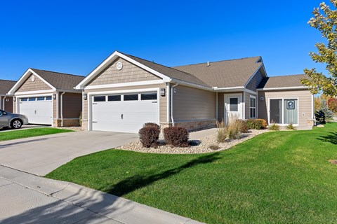 A two-story house with a garage and a driveway.