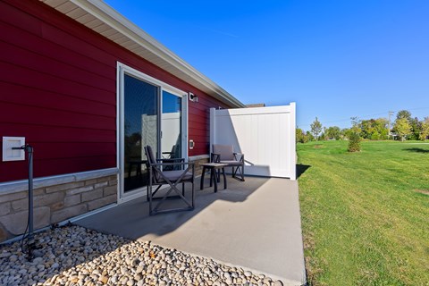 A red house with a patio and a white wall.
