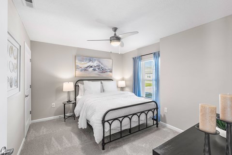 A bedroom with a large bed and a painting on the wall.