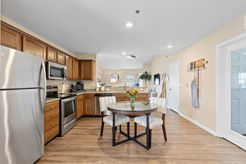 A kitchen with a table and chairs in the middle of the room.