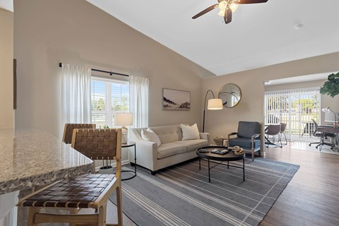 A living room with a white couch and a wooden chair.