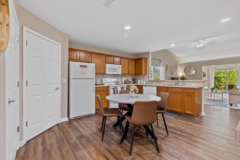 A kitchen with brown cabinets and a white fridge.