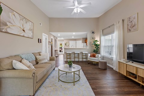 A living room with a beige couch and a coffee table.