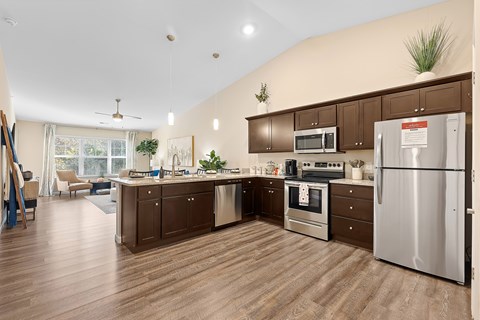 A kitchen with brown cabinets and a stainless steel refrigerator.
