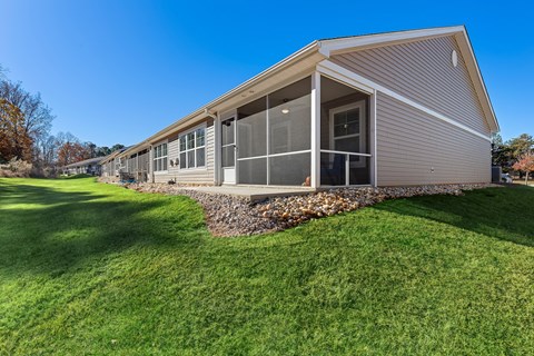 A house with a grey roof and a green lawn in front.