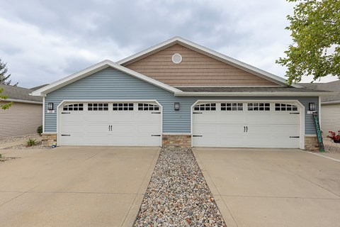 A two-car garage with a stone border in front.