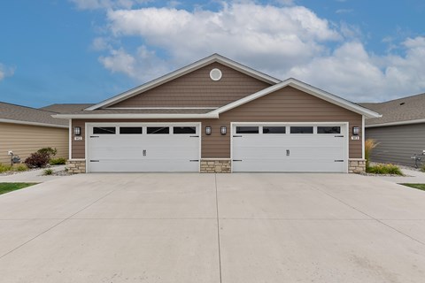 A two-car garage with a brown roof and white garage doors.