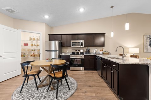 A kitchen with a table and chairs in the middle of the room.