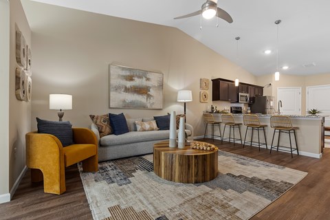 A living room with a yellow chair and a grey couch.