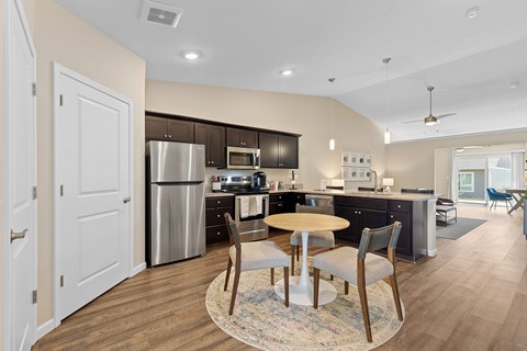 A modern kitchen with a dining table set for two.
