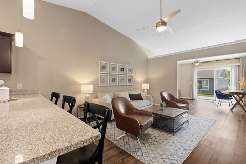 A modern living room with a marble table and brown leather chairs.