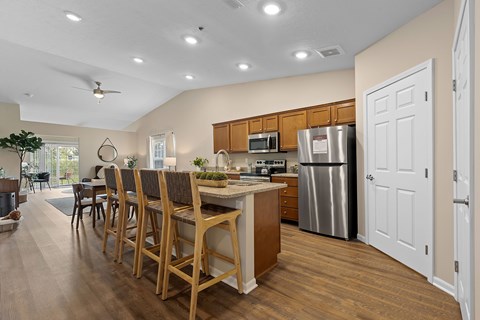 A kitchen with wooden chairs and a counter.