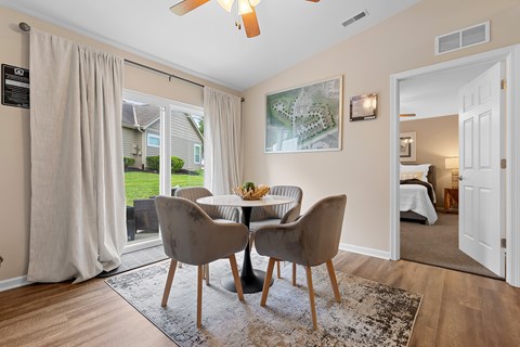 A dining room with a table and chairs.