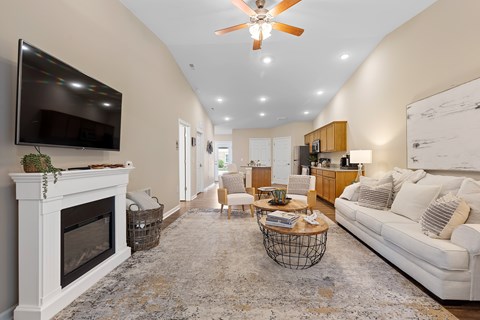 A living room with a fireplace and a television mounted on the wall.