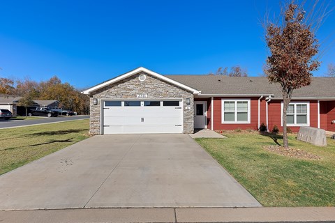 A red brick house with a white garage door.