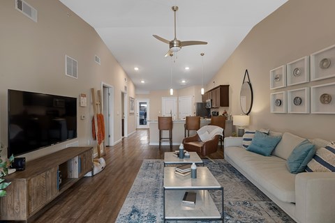 A living room with a white couch and a wooden floor.