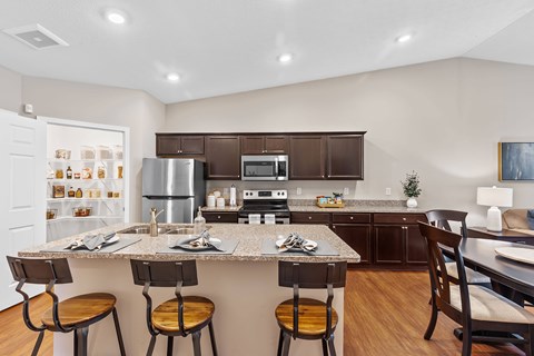 A kitchen with a table and chairs.