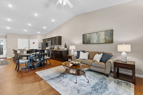 A living room with a grey couch, a coffee table, and a painting on the wall.