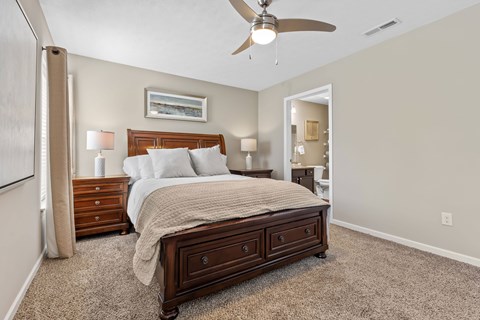 A bedroom with a large bed and a ceiling fan.