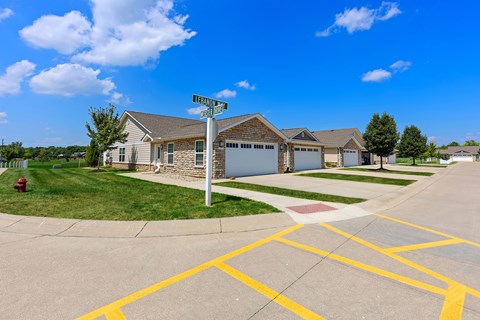 A street view of a residential area with houses and a street sign.