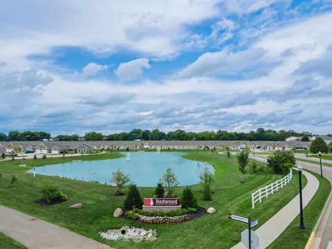 A beautiful aerial view of a community with a large swimming pool and a sign that reads "Redwood".