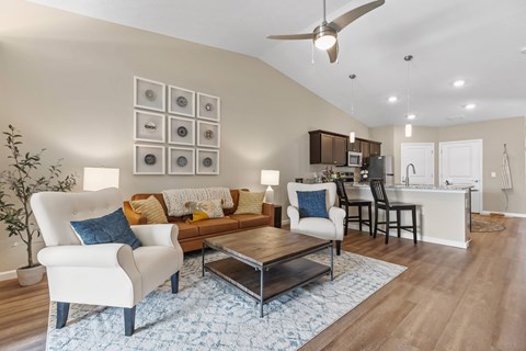 A living room with a white chair and a brown couch.