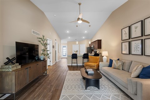 A living room with a grey couch and a wooden floor.