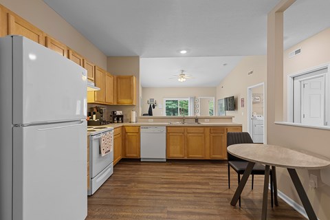 A kitchen with a white refrigerator and wooden cabinets.