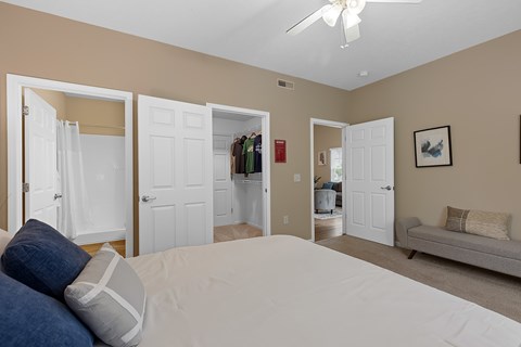 A bedroom with a large bed and a ceiling fan.