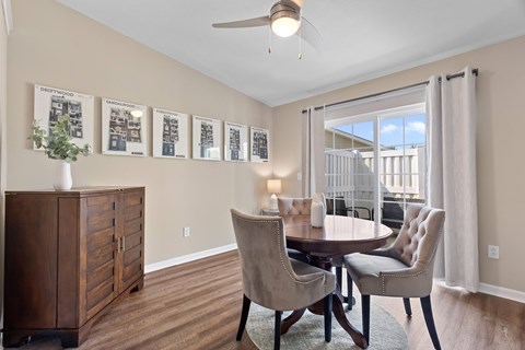 A dining room with a table and chairs and pictures on the wall.