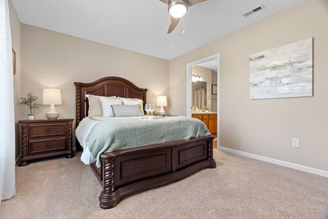 A bedroom with a large bed and a painting on the wall.