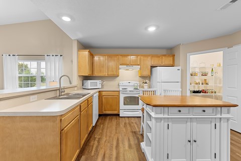 A kitchen with wooden cabinets and a white fridge.