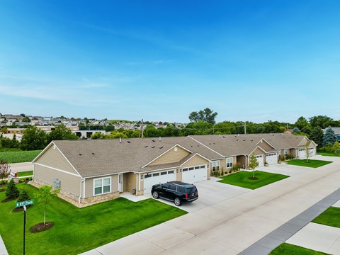A residential area with houses and a car parked in front of one.