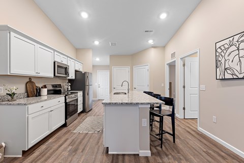 A kitchen with a bar island and a dining area.