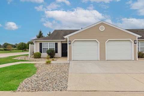 A house with a grey roof and two garages.