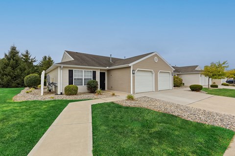 A house with a grey roof and a white garage door.