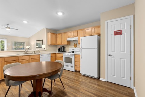 A kitchen with a table and chairs and a refrigerator.