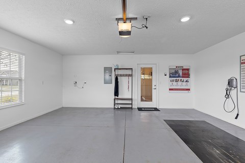 A spacious room with a door, window, and a wall-mounted hose reel.
