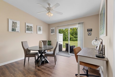 A dining room with a table and chairs.