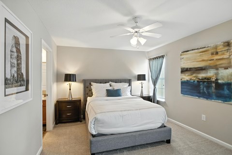A bedroom with a large bed and a ceiling fan.