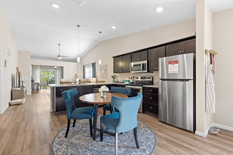 A kitchen with a table and chairs in the middle of the room.