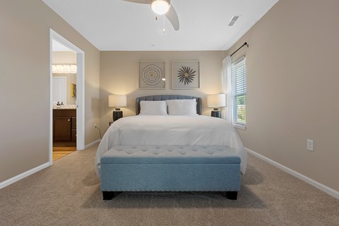 A bedroom with a large bed and a ceiling fan.