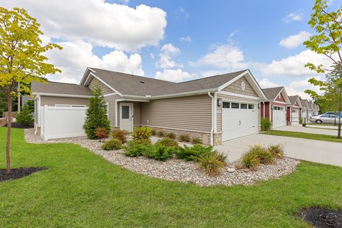 A house with a grey roof and a white garage door.